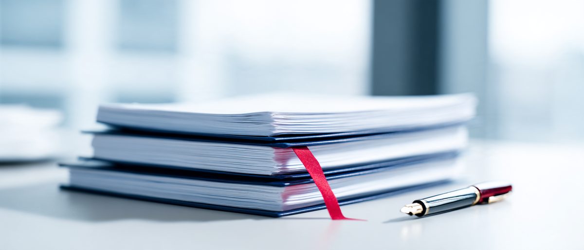 Documentos apilados con una carpeta azul